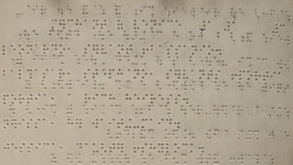 6 lines of Braille, the page also shows that in between each line the paper has been embossed in Braille on the reverse so you can see the indents of the characters from the next page.